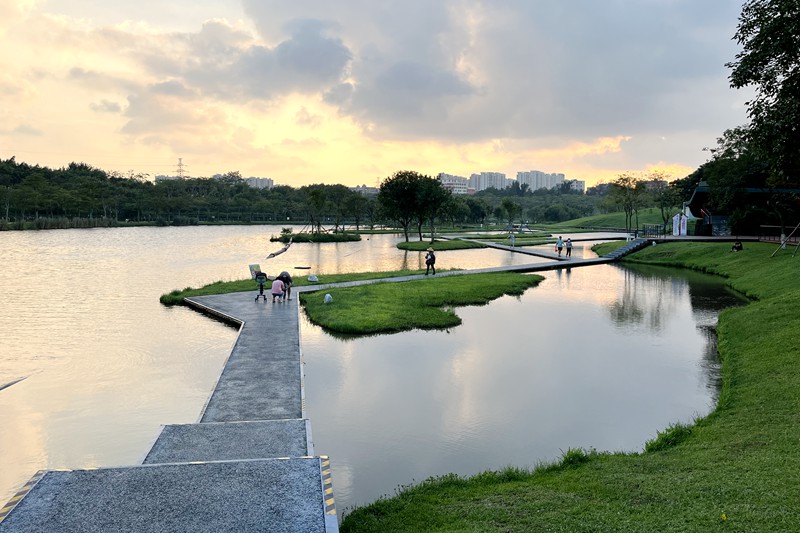 ?？诃偵絽^(qū)美舍河鳳翔濕地公園一隅，市民在親水步道享受落日余暉下的天光水色。