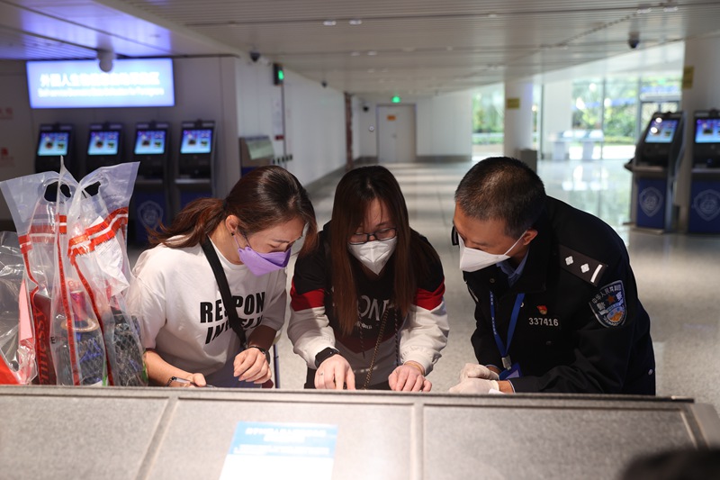 ?？诿捞m邊檢站民警正在指導(dǎo)入境旅客填寫外國(guó)人登記卡。朱晨鵬攝