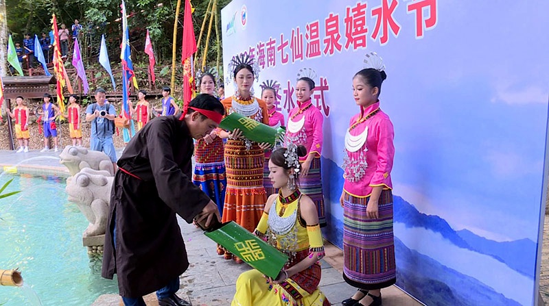 “長老”從圣水潭中舀起象征吉祥如意的“圣水”裝滿竹筒。保亭縣委宣傳部供圖