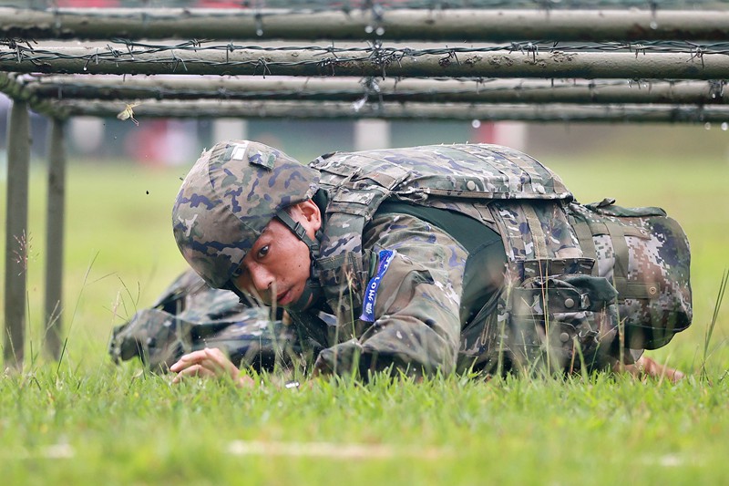 參賽官兵全副武裝通過(guò)低樁網(wǎng)。武警海南總隊(duì)供圖