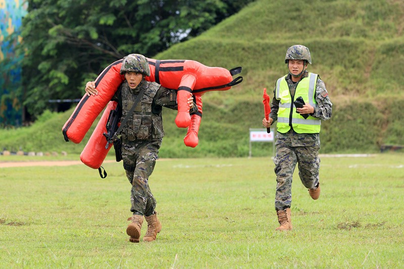 參賽官兵完成射擊后快速轉(zhuǎn)運“傷員”。武警海南總隊供圖