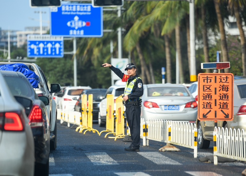 海口市濱海大道交警正在指引過海車輛有序通行前往新海港碼頭。石中華攝