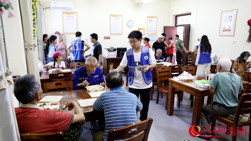 志愿者正在給用餐的老人盛湯。人民網(wǎng)記者 符武平攝