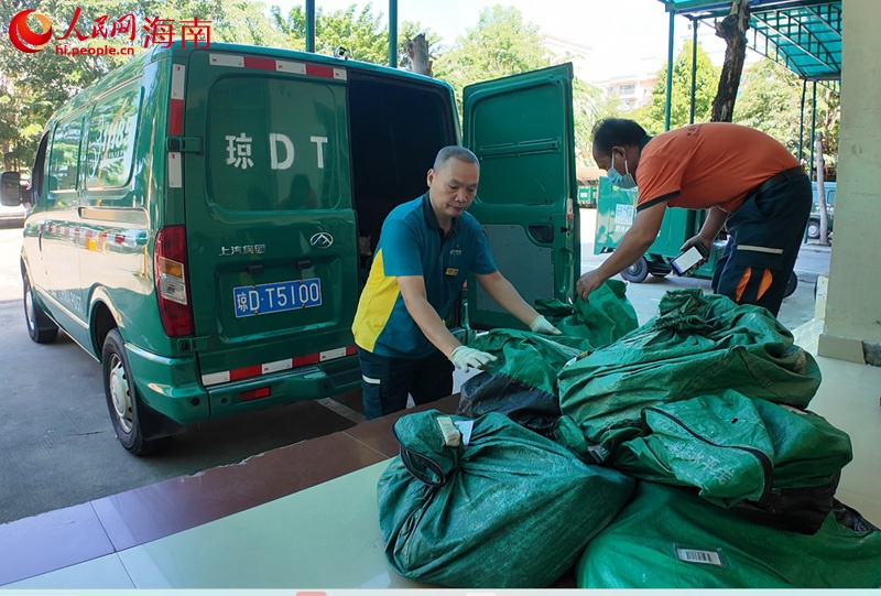 吳育仙將郵件搬運(yùn)裝車。人民網(wǎng)記者 李學(xué)山攝