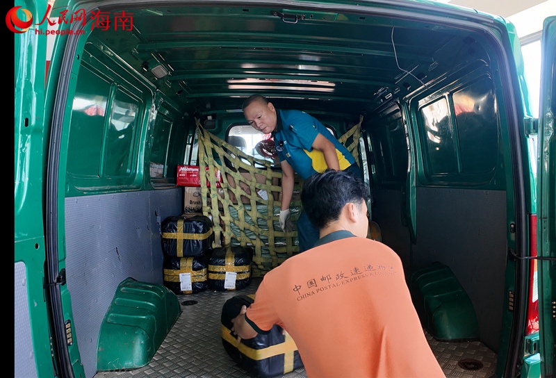 吳育仙將郵件搬運(yùn)裝車。人民網(wǎng)記者 李學(xué)山攝